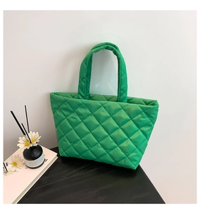 Close-up of quilted green tote bag with diamond pattern stitching and soft padded handles