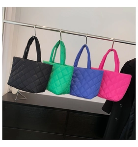 Quilted nylon tote bags in black, green, blue, and pink hanging on a metal rack