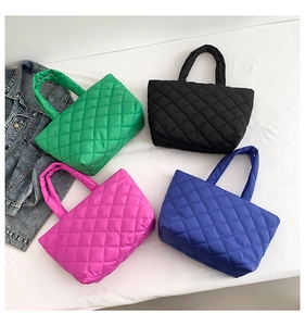 Colorful quilted tote bags in green, black, pink, and blue shown on a flat white surface