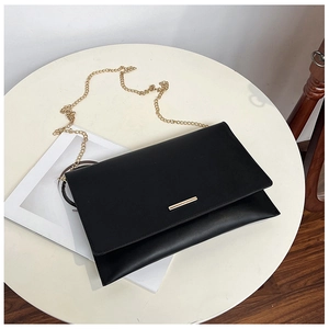 Top view of a black envelope bag with a gold metal bar and delicate chain strap detail