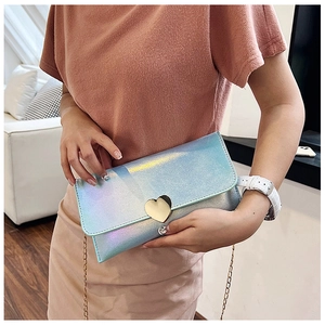 Detail showing laser hologram light blue envelope bag with golden heart clasp and chain strap