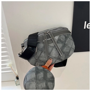 Detail van vintage grijze gewatteerde borsttas met ronde pouch en brede schouderriem