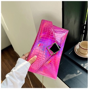 Metallic pink crocodile pattern envelope clutch with gold chain strap in hands