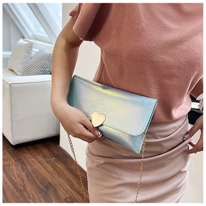 Chic iridescent envelope clutch bag with gold heart clasp shown on a crossbody chain