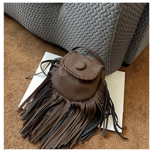Close-up of brown suede saddle bag showing fringe tassels and detailed stitching