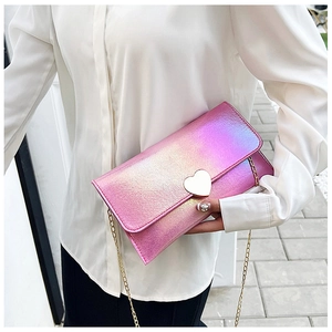 Close-up of pink laser heart buckle on crossbody handbag with gold chain strap