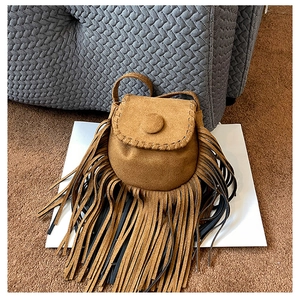 Detailed view of the brown faux suede material and long fringe tassels on the saddle bag