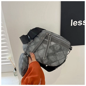 Detail van grijze gewatteerde crossbodytas met ronde portemonnee en brede riem