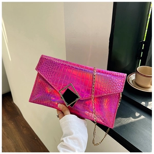 Detail of fuchsia holographic crocodile texture on envelope bag with gold chain strap