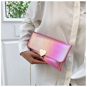 Close-up of iridescent envelope clutch bag with gold heart clasp and chain strap
