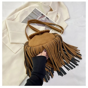 Detail of brown faux suede bucket bag featuring layered long tassels and gold metal buckle