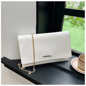 Close-up of a white rectangular crossbody bag with gold metal trim and chain strap