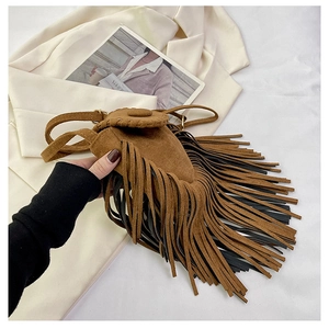 Close-up of vintage brown suede saddle bag featuring double-layered fringe and fine stitching
