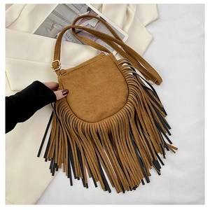 Detail shot of brown suede crossbody bag featuring long bohemian style fringe tassels