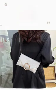 Detail of silver sequined envelope bag with elegant golden ring buckle and chain strap