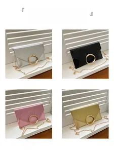 Detail view of four colors of glitter envelope clutch bags with gold ring clasp and chain