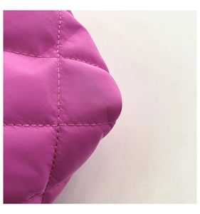 Detail of rose pink quilted nylon fabric with classic diamond stitching and satin finish