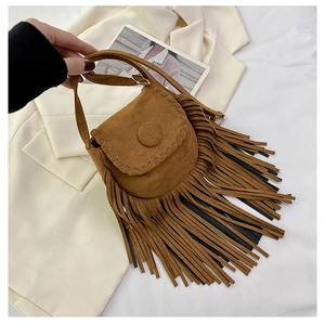 Detailed close-up of brown suede saddle bag featuring long tassels and stitching