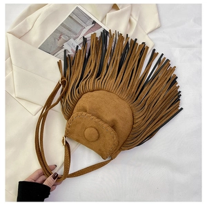 Detail of bohemian suede crossbody bag showing long brown fringe and textured flap cover