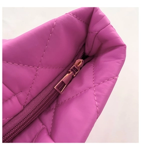 Detailed close-up of purple quilted nylon fabric with smooth metal zipper closure
