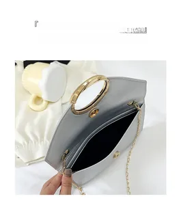 Detail of silver envelope clutch showing large capacity compartment and gold ring handle