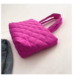 Detailed macro view of hot pink quilted nylon texture and diamond stitch patterns
