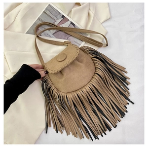 Close-up of bohemian khaki suede saddle bag featuring long fringe and gold metal hardware
