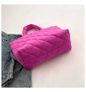 Top view of bright pink quilted tote bag with diamond pattern on white background