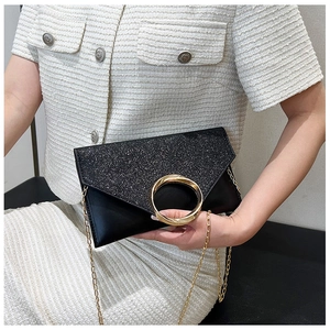 Detail of black glitter envelope clutch with large gold ring buckle and chain strap
