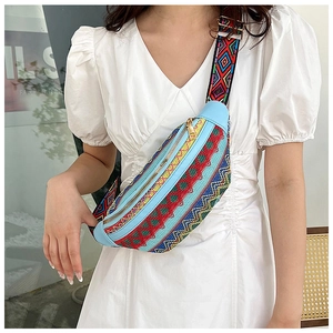 Close-up of bohemian embroidered belt bag with vibrant geometric patterns on white dress