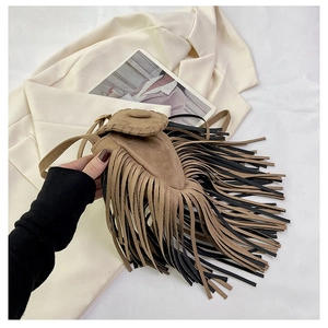 Detail showing Bohemian suede saddle bag with brown and black fringe tassels and flap closure