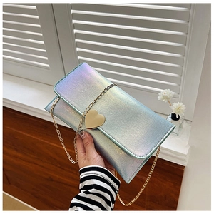 Detailed close-up of colorful laser fabric and golden heart-shaped clasp on a handbag