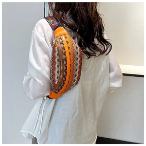 Close-up of bohemian embroidered waist bag in bright orange with geometric strap
