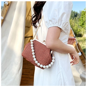 Détail du sac tissé avec poignée en perles surdimensionnées et chaîne dorée fine