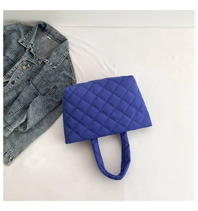Close-up of Klein blue quilted tote bag with soft diamond stitching and padded handle