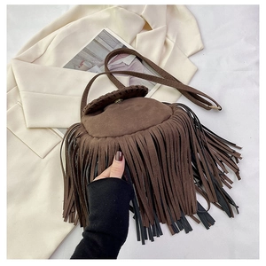 Detailed close-up of dark brown suede saddle bag with long fringe and retro tassels