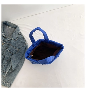 Detailed top view of navy blue quilted tote bag with interior lining and zipper closure