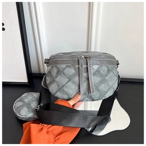 Detail van grijze gewatteerde crossbodytas met dubbele ritssluiting en kleine ronde portemonnee