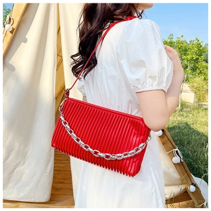 Outdoor shot of a red pleated shoulder bag with silver chunky chain for fashion styling