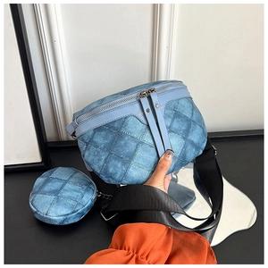 Detailopname van denim crossbodytas met blauwe stiksels en een kleine ronde portemonnee