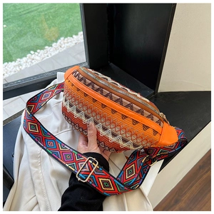 Detail of bohemian woven waist bag with colorful geometric strap and orange leather trim