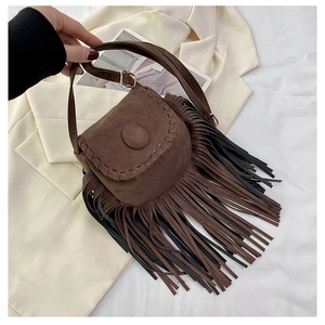 Close-up of brown suede saddle bag featuring long tassels and decorative stitching detail