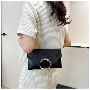 Detailed view of black glitter envelope clutch bag with gold ring and chain strap