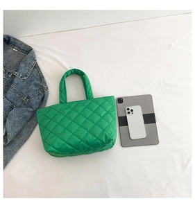 Detail view of a bright green quilted nylon tote bag with large storage capacity