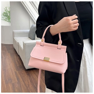 Close-up of pink lychee pattern leather bag featuring elegant gold metal lock detail