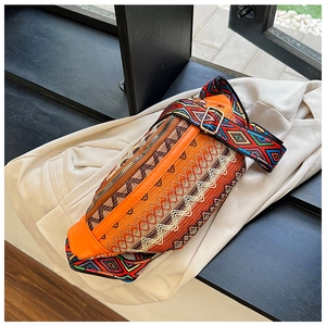 Detail of ethnic geometric embroidery on orange waist bag with adjustable wide strap