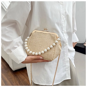 Détail d'un sac tressé rétro avec poignée en perles et bandoulière chaîne dorée