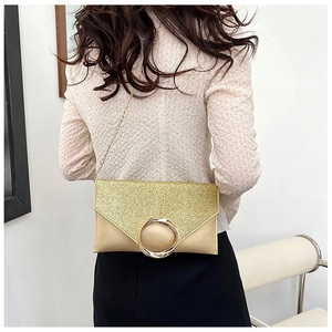 Detail of champagne gold envelope clutch with metallic ring buckle and fine chain strap