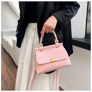 Close-up of pink litchi grain texture handbag with elegant gold rectangular lock detail