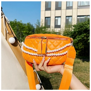 Détail du sac banane matelassé orange vif avec doubles chaînes de perles et bandoulière